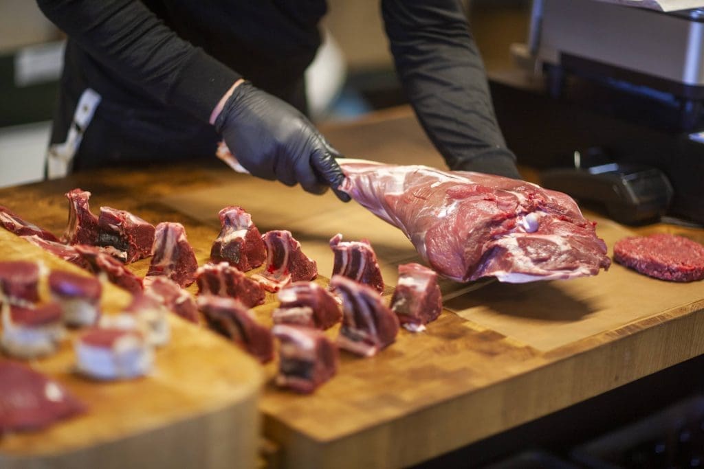 Slagter i gang med at skære kød ud